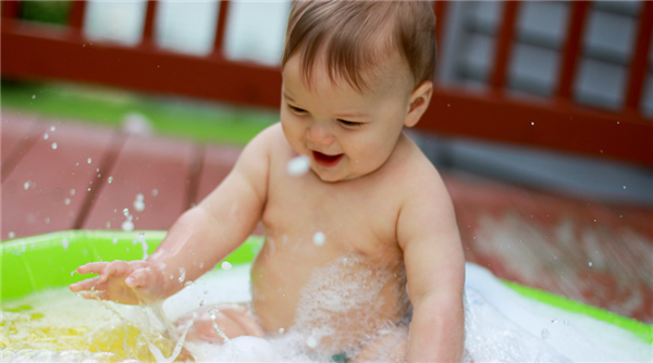 Baby in bath with bubbles and toys