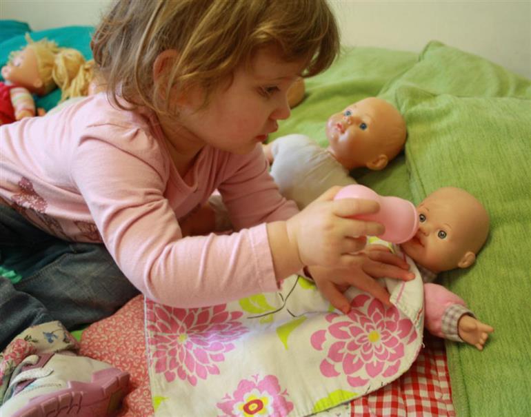 toddlers playing with baby dolls